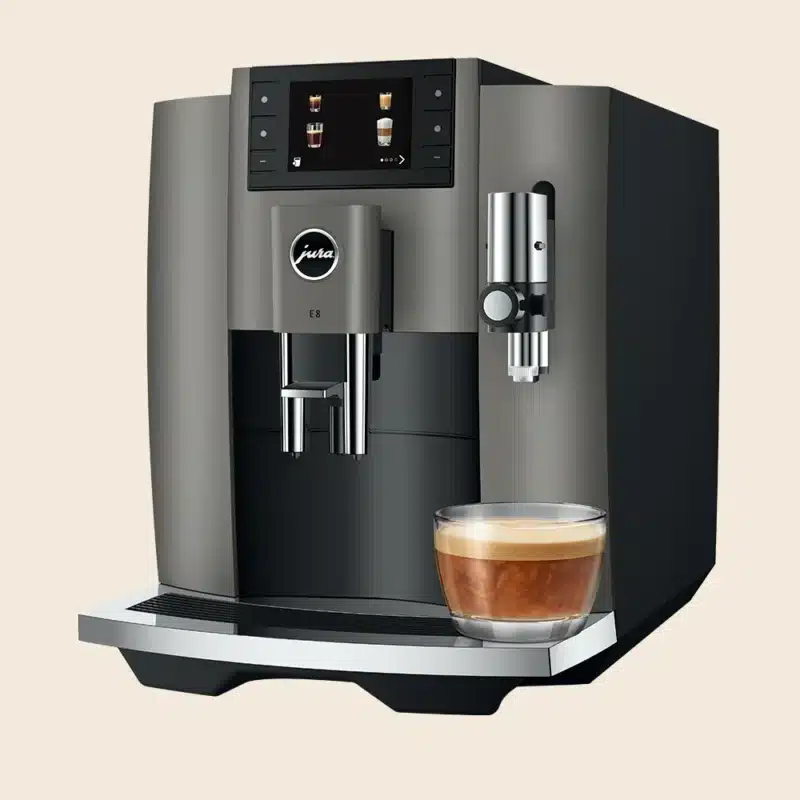 Den fuldautomatiske espressomaskine Jura E8 (EC) i farven Dark Inox, som netop har brygget en flat white